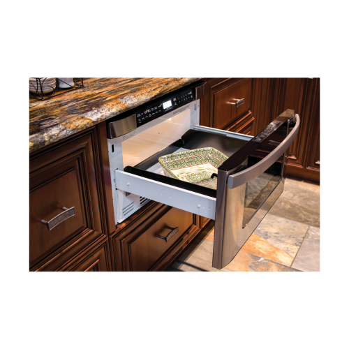 Built-in microwave drawer open with decorative plates inside, set in a kitchen with dark wood cabinetry and stone flooring