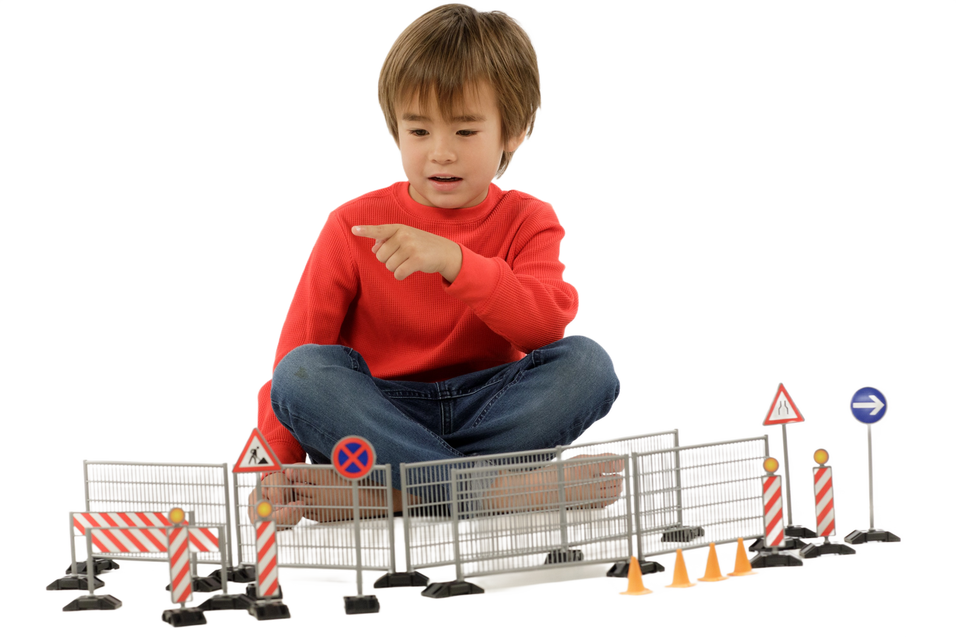 Child playing with a construction set featuring plastic railings, site warning signs, pylons, and road cones for home improvement play