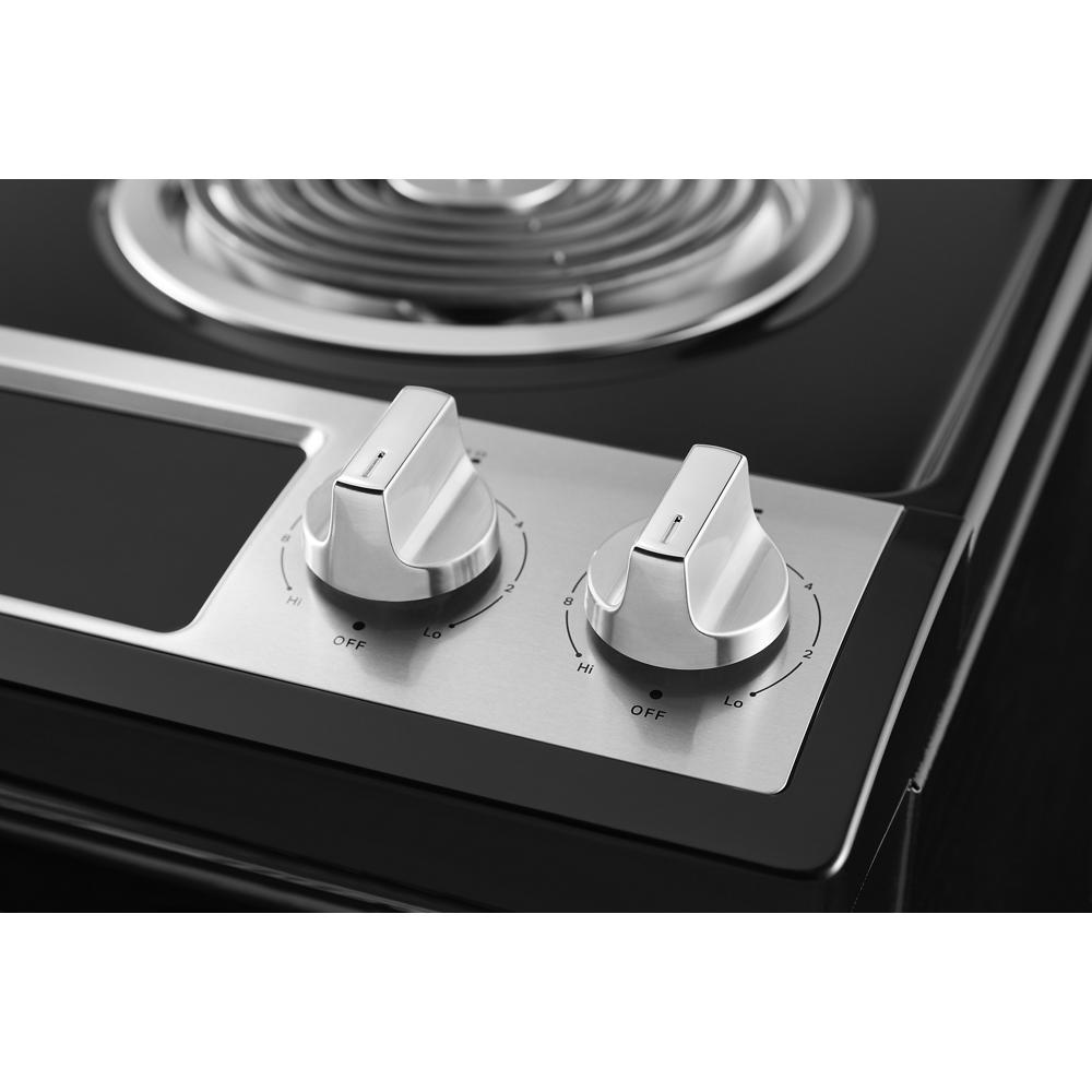 close-up of stainless steel control knobs on electric range cooktop for home improvement and kitchen appliances