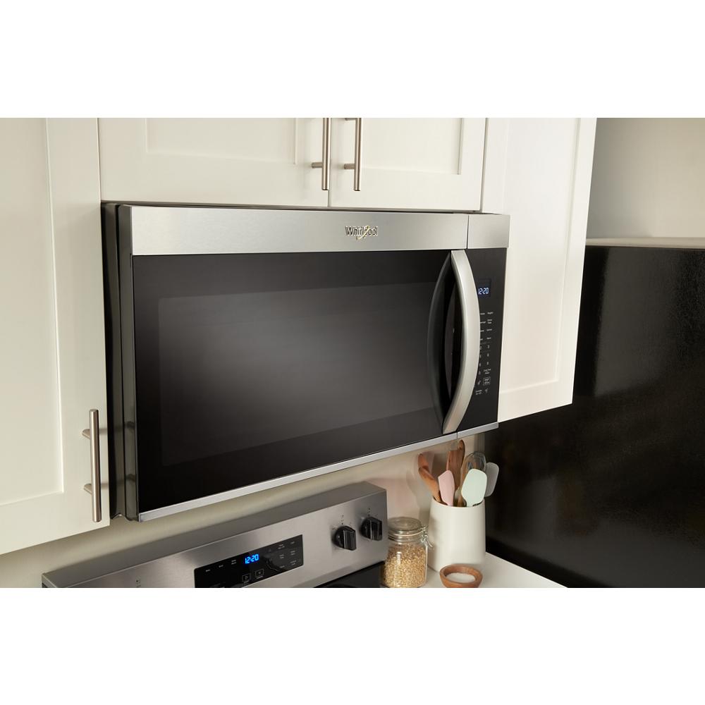 Stainless steel wide over the range microwave with sensor cooking installed above electric stove in modern kitchen setting