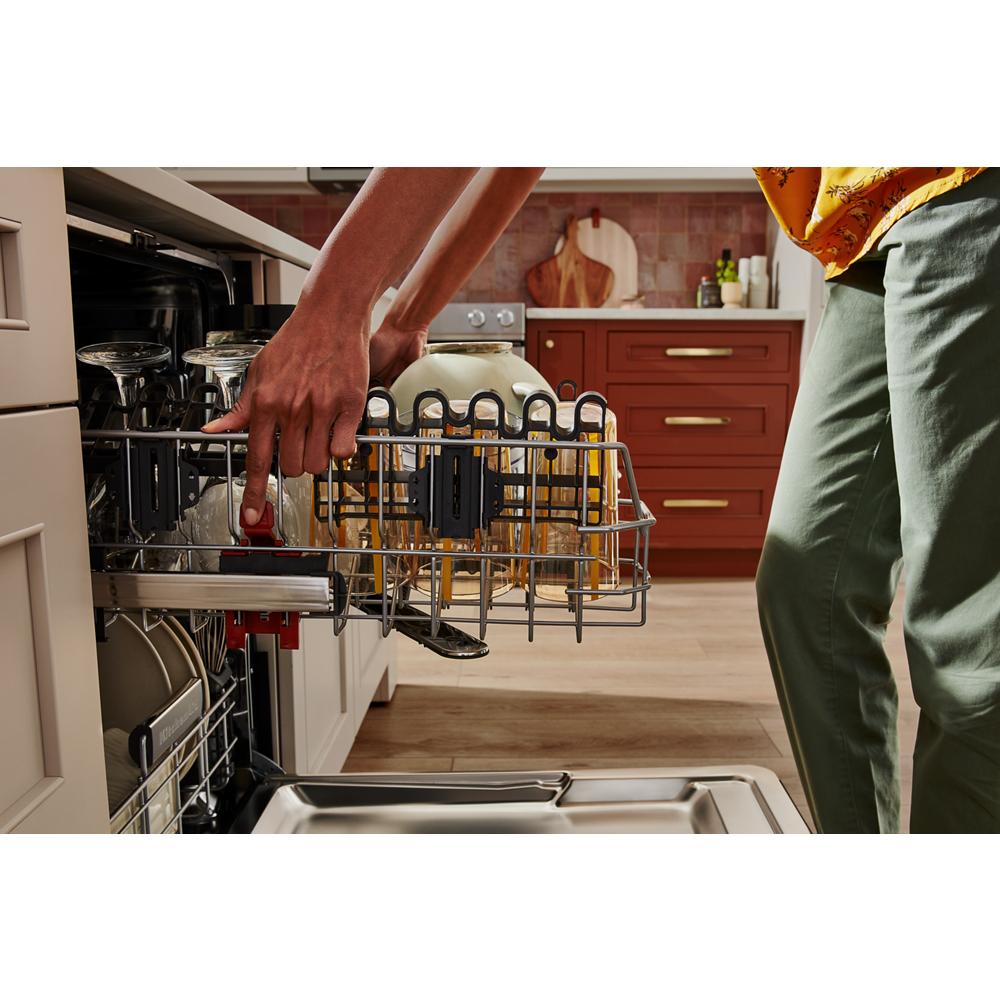 Person loading lower rack of a panel-ready dishwasher with glassware and utensils in Kitchen & Kitchenware category