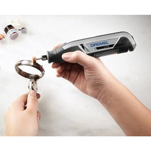 Handheld rotary tool with polishing attachment cleaning a metal ring for detailed home improvement tasks