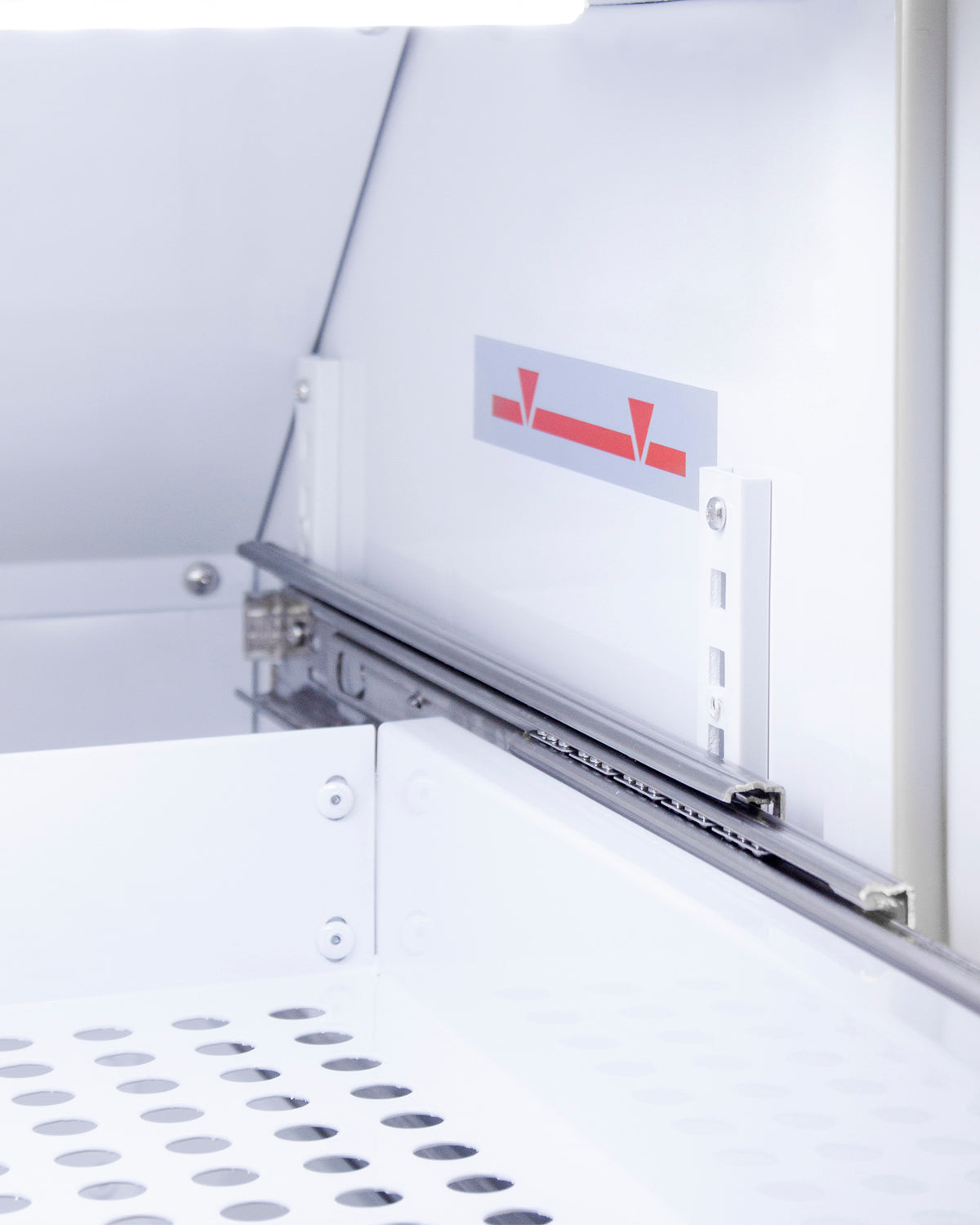 Close-up of removable white metal drawer with ventilation holes inside upright vaccine refrigerator from appliances collection