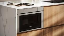 Built-in stainless steel drawer microwave integrated into modern kitchen cabinetry in Bosch microwaves and appliances collection