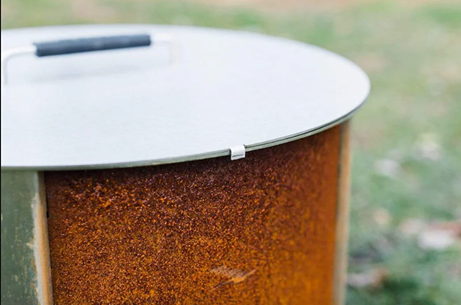 Round metal fire pit cover with black handle for outdoor use in tools and home improvement projects
