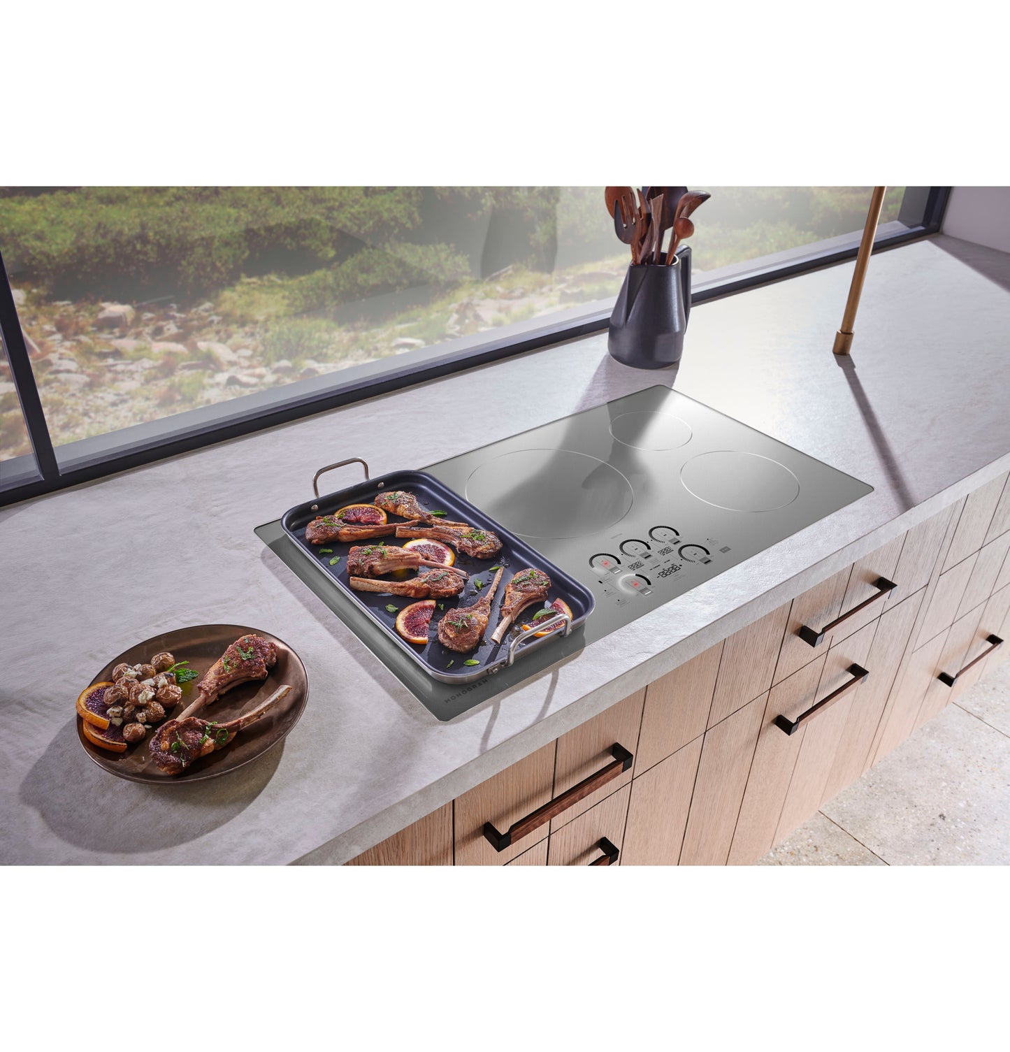 Sleek induction cooktop with digital touch controls, shown with a grill pan and cooked meat in a modern kitchen setup.