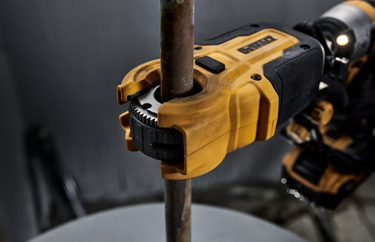 Yellow and black impact tool attachment cutting a metal pipe for precise plumbing in tools and home improvement tasks