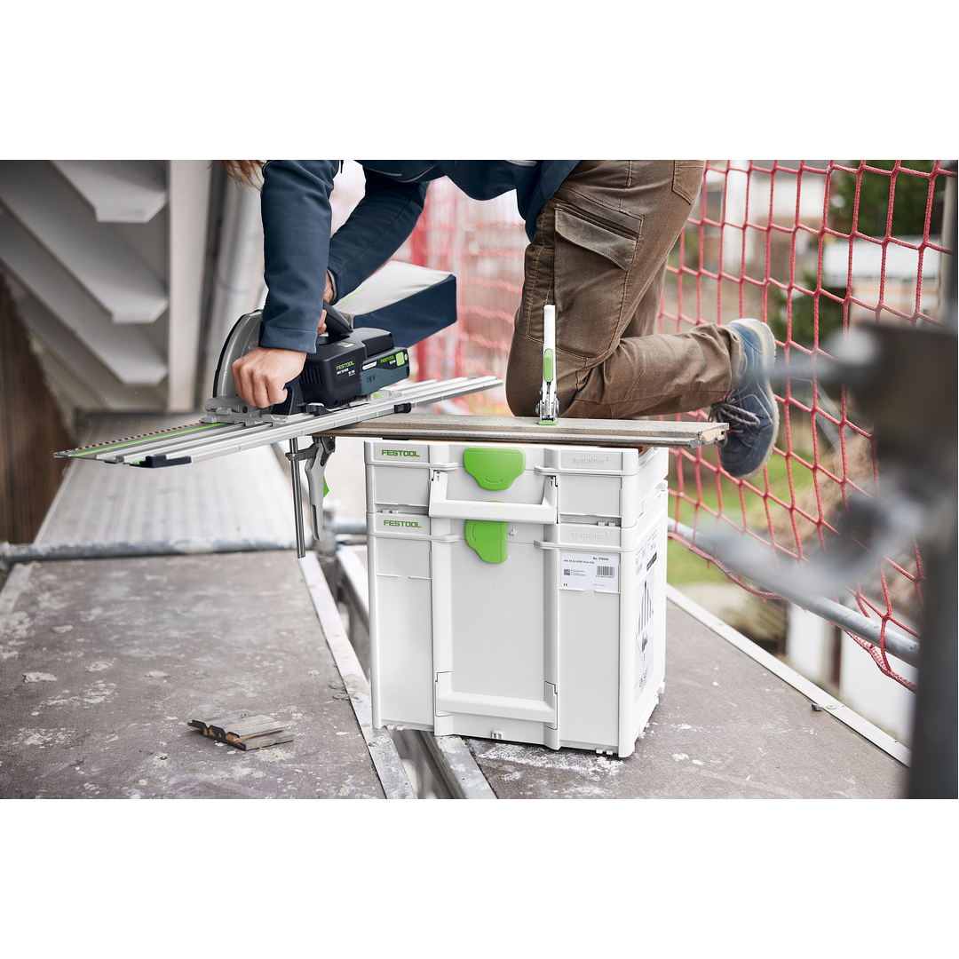 Person using a Festool power saw mounted on a guide rail supported by a white and green modular storage system on a construction site floor, demonstrating tool storage and woodworking efficiency.