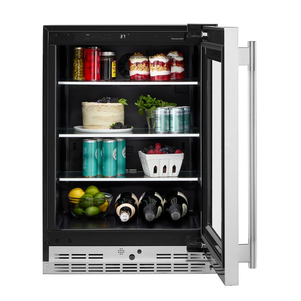 Undercounter refrigerator with clear glass door, metallic-trimmed shelves, and LED lighting in KitchenAid appliances collection