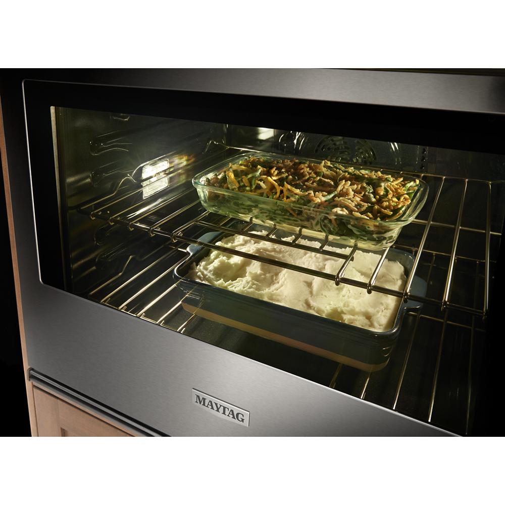 Glass baking dishes with casserole and mashed potatoes cooking inside stainless steel wall oven combo from kitchen appliances