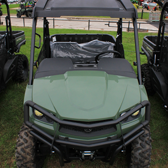 Green mid-size crossover utility vehicle with reinforced front brush guard and rugged tires for outdoor use and home improvement tasks