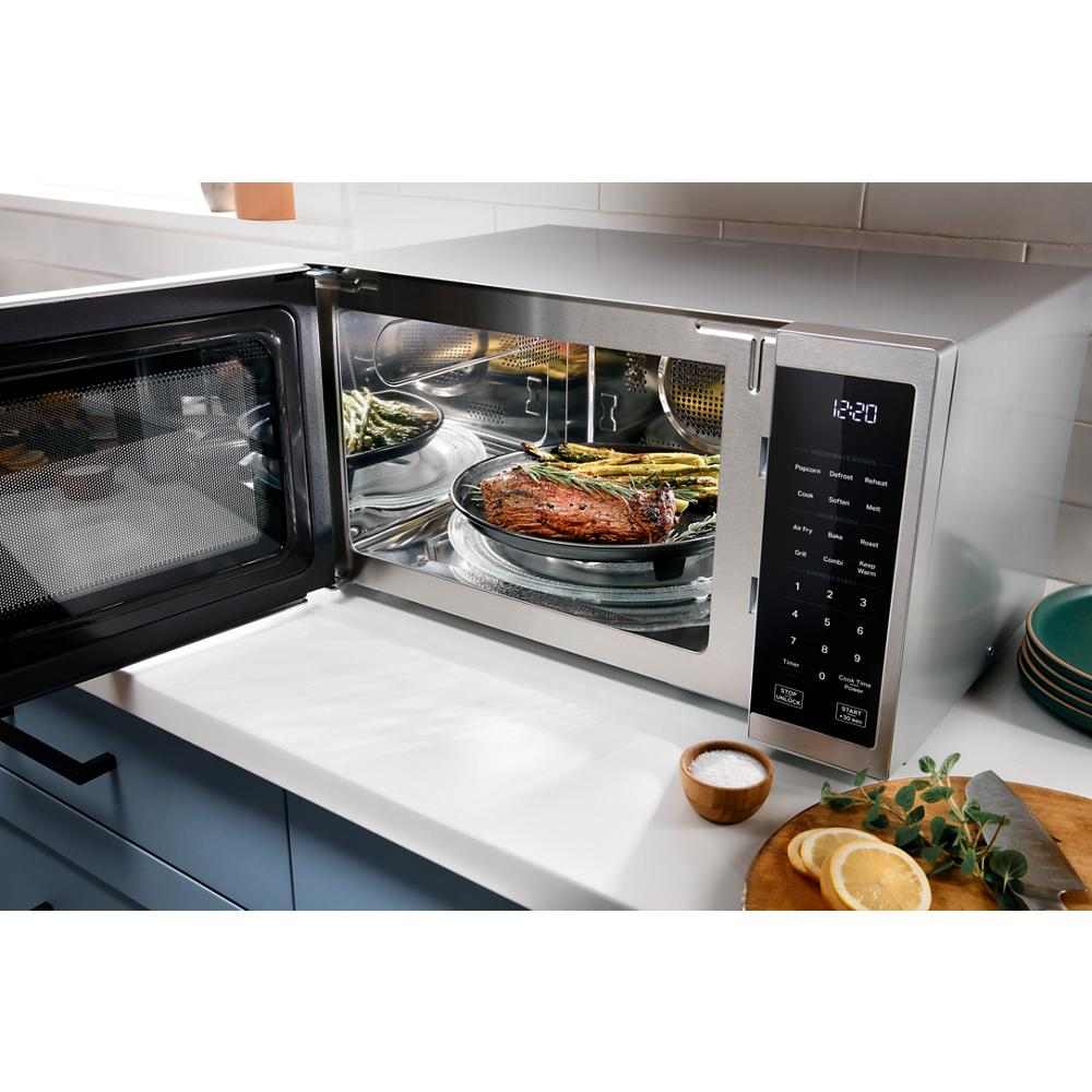 Stainless steel countertop microwave with digital display and all-in-one cooking modes in modern kitchen setting