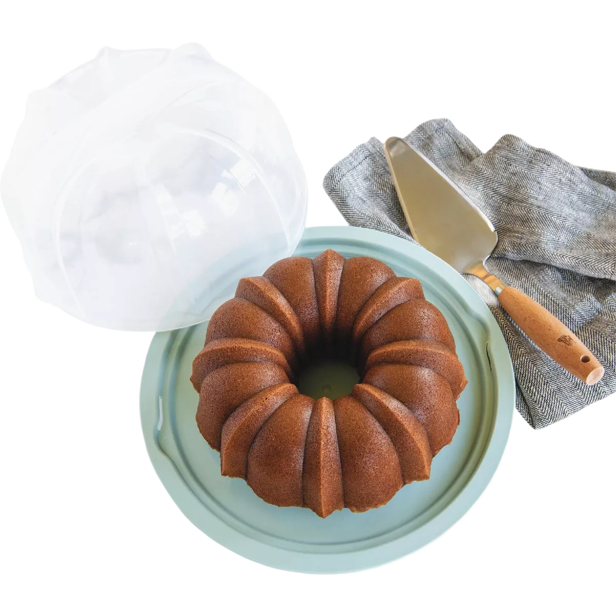 Light green bundt cake carrier with clear locking lid, cake server, and gray linen napkin for kitchen storage under $50 collections