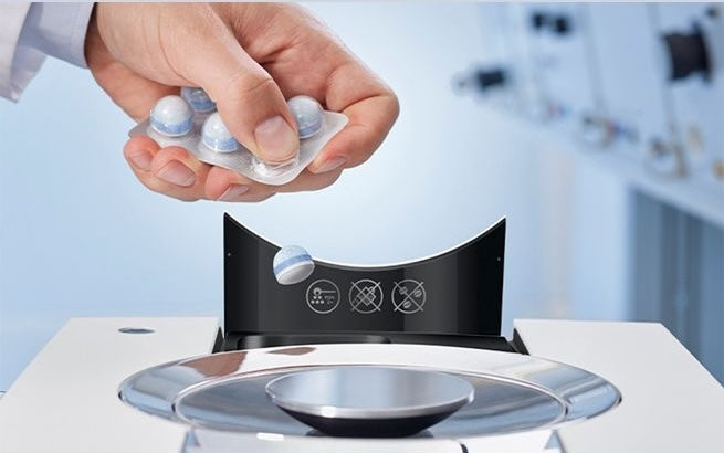 Hand holding cleaning tablets to insert in coffee machine, part of cleaning supplies and kitchenware under $50 collection
