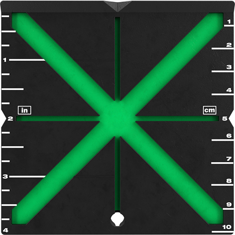 Square black laser alignment target with green illuminated cross lines and white measurement markings in inches and centimeters