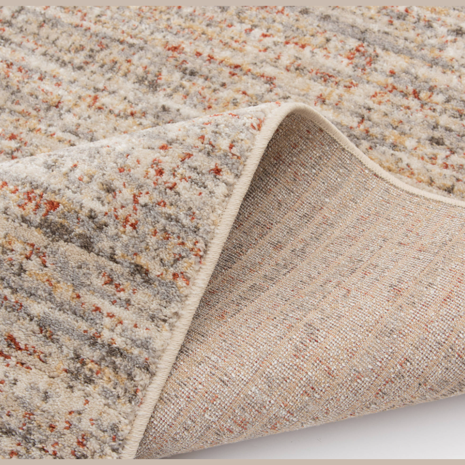Close-up view of textured area rug with cream, rust, blue, yellow, and green tones in home decor collection