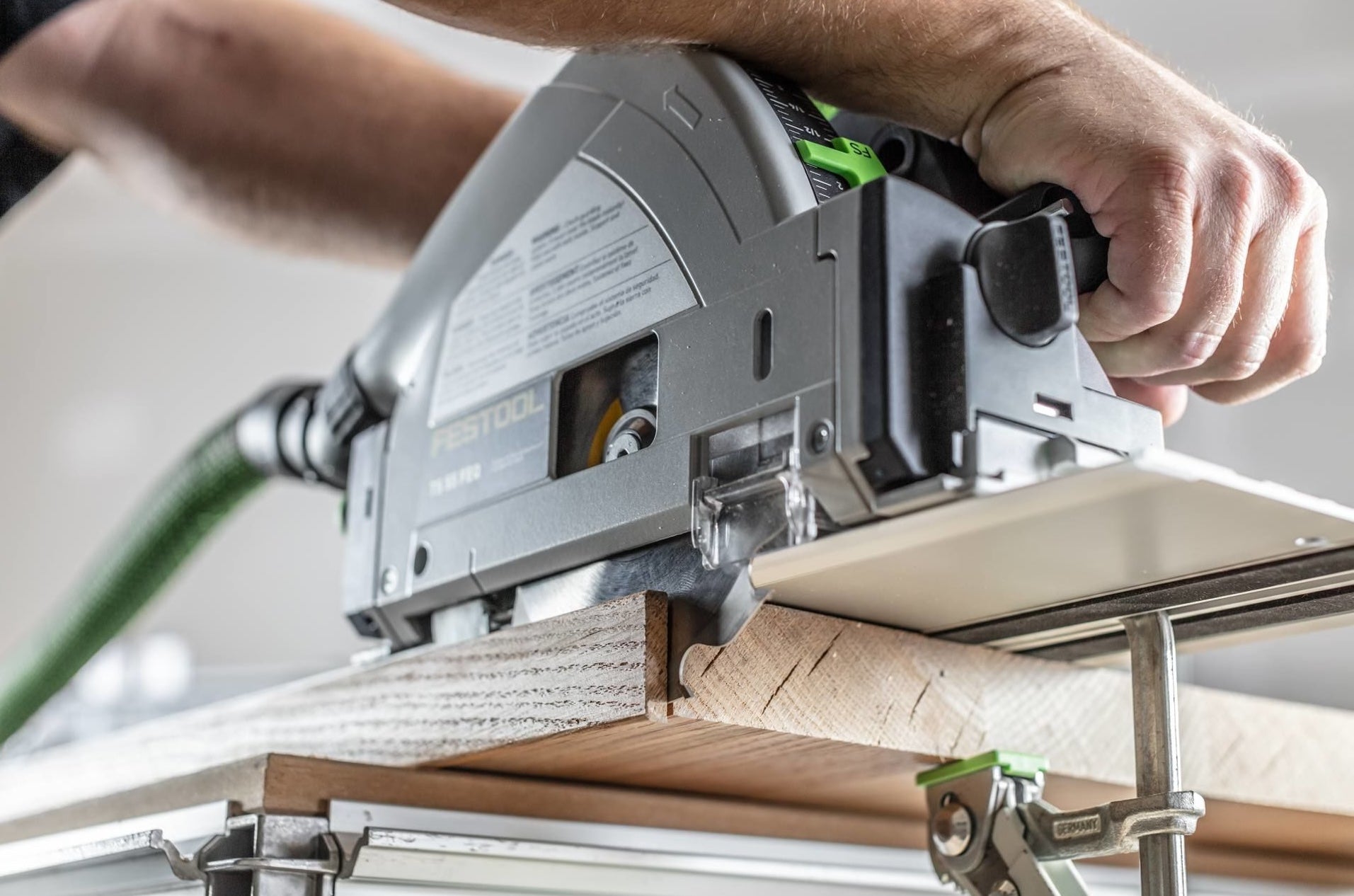 Close-up of plunge-cut track saw making precise cut on wood plank in power tools and home improvement setting