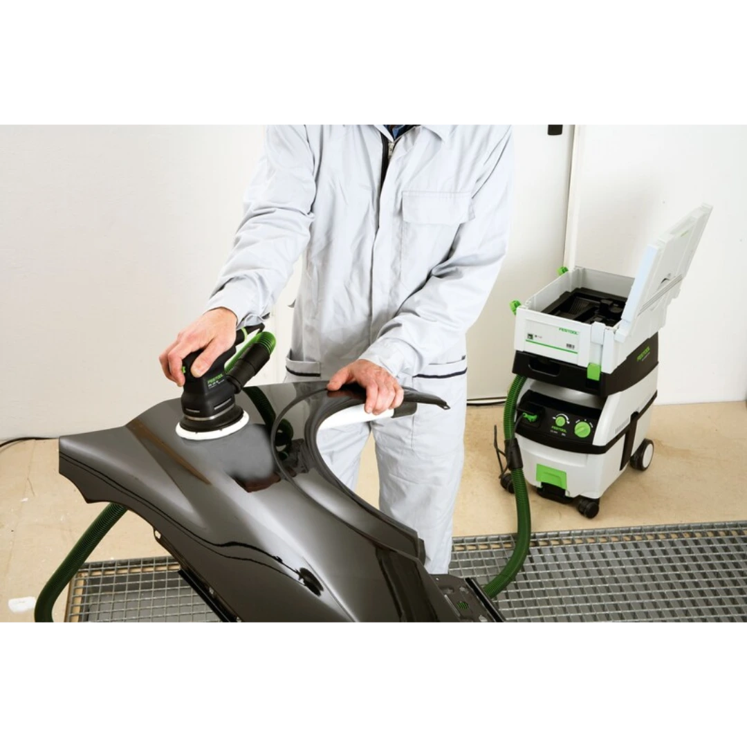 Person using Festool power tool with supersoft sanding pad on glossy black automotive panel in woodworking accessories