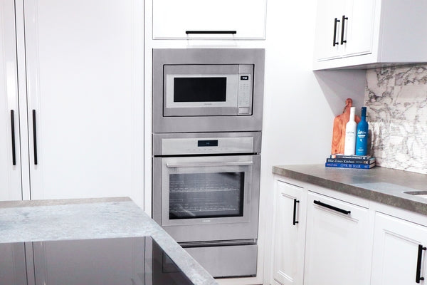 Built-in stainless steel microwave with left side door above built-in oven in modern kitchen appliances collection