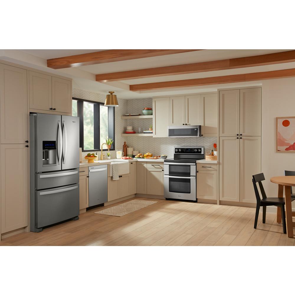 Modern kitchen featuring a stainless steel electric double oven range with true convection and beige cabinetry.