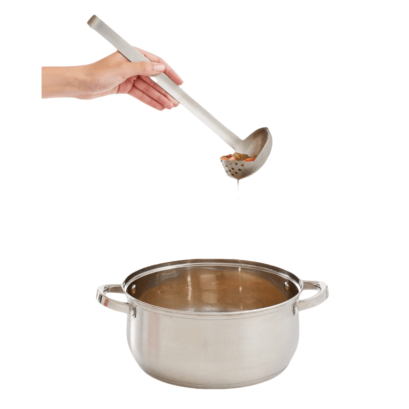 Hand holding stainless steel straining ladle draining broth into a stainless steel cooking pot in kitchenware setting