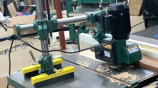 Green power feeder mounted on cast iron table with yellow magnetic base in saw and power tool accessories collections