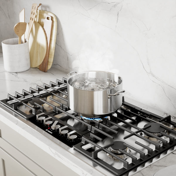 Stainless steel gas cooktop with multiple burners, boiling pot, and modern kitchen setup featuring kitchenware accessories