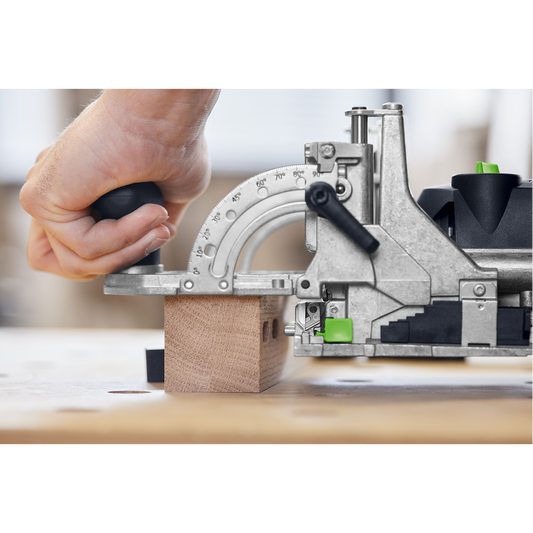 Close-up of a hand operating a precision joiner tool to make angled cuts on a wood block in a woodworking workshop, part of power and woodworking tools collections.