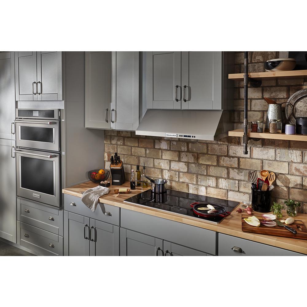 Modern kitchen featuring a 36" electric cooktop with five touch controls, gray cabinets, and brick backsplash wall