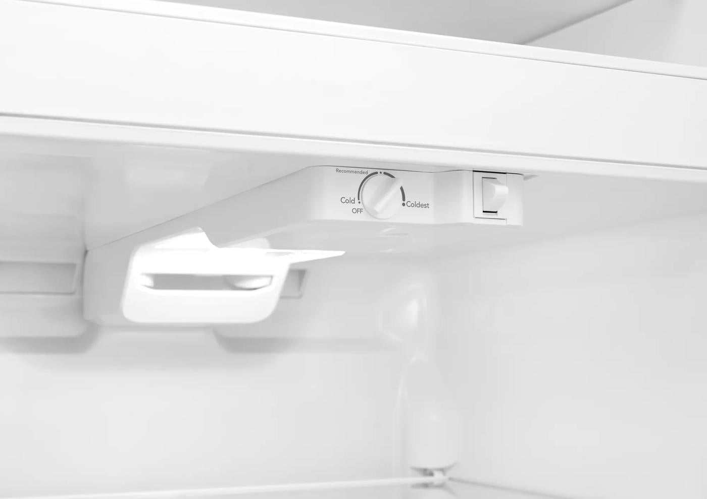 Close-up of thermostat control and LED light inside white top freezer refrigerator in appliances collection