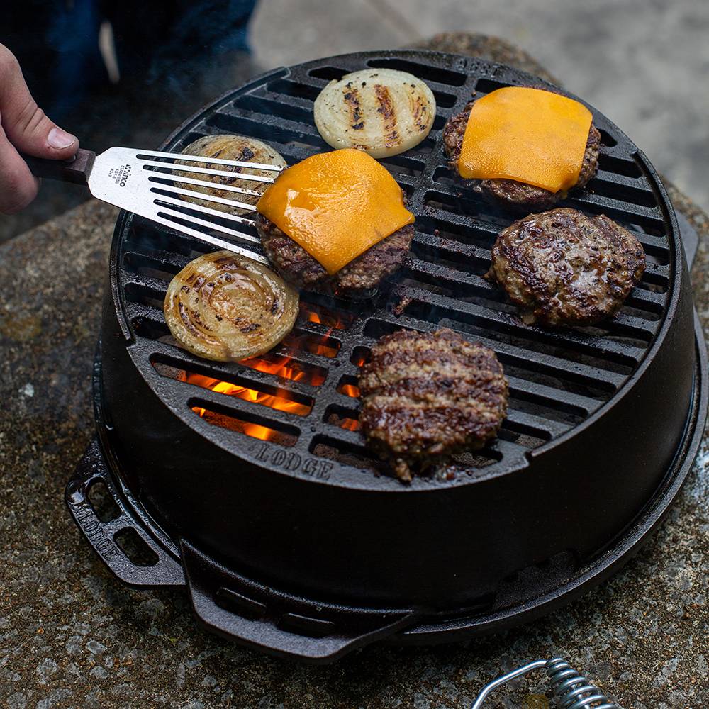 Cast iron grill pan with burgers and onions cooking over open flame in outdoor kitchenware setting under $100 collection