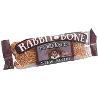 Jerky style dog treat shaped like a bone with packaging featuring rustic stew recipe branding and The Wild Bone logo
