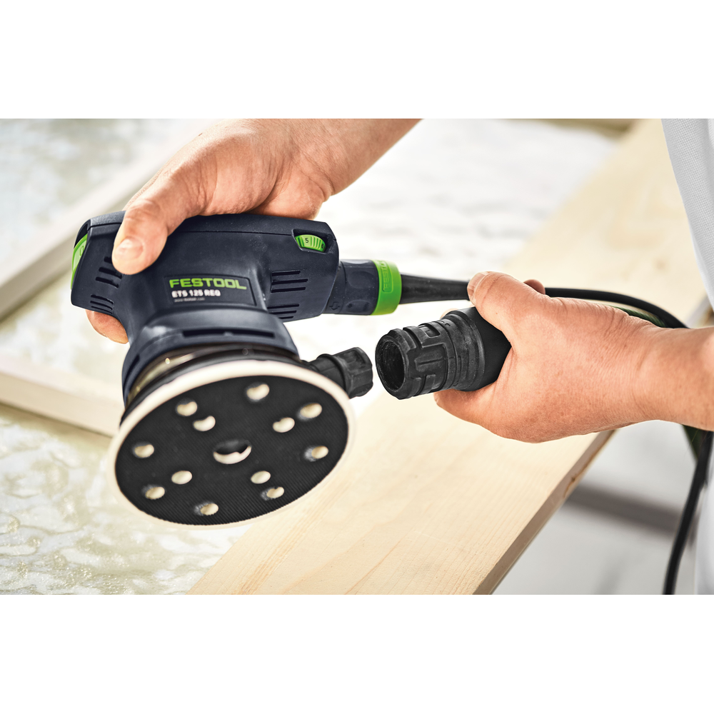 Hands connecting a Festool ETS 125 random orbit sander to a dust extractor hose for woodworking tools use