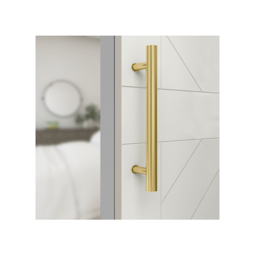 Brushed gold 12-inch barn door pull installed on white wood interior door in home improvement hardware collections