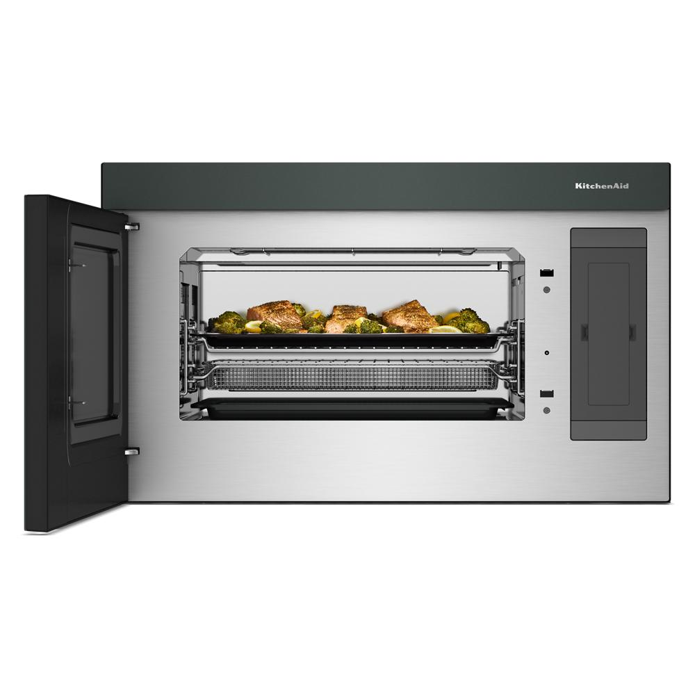 Stainless steel multifunction over-the-range microwave with open door showing roasting chicken and vegetables inside