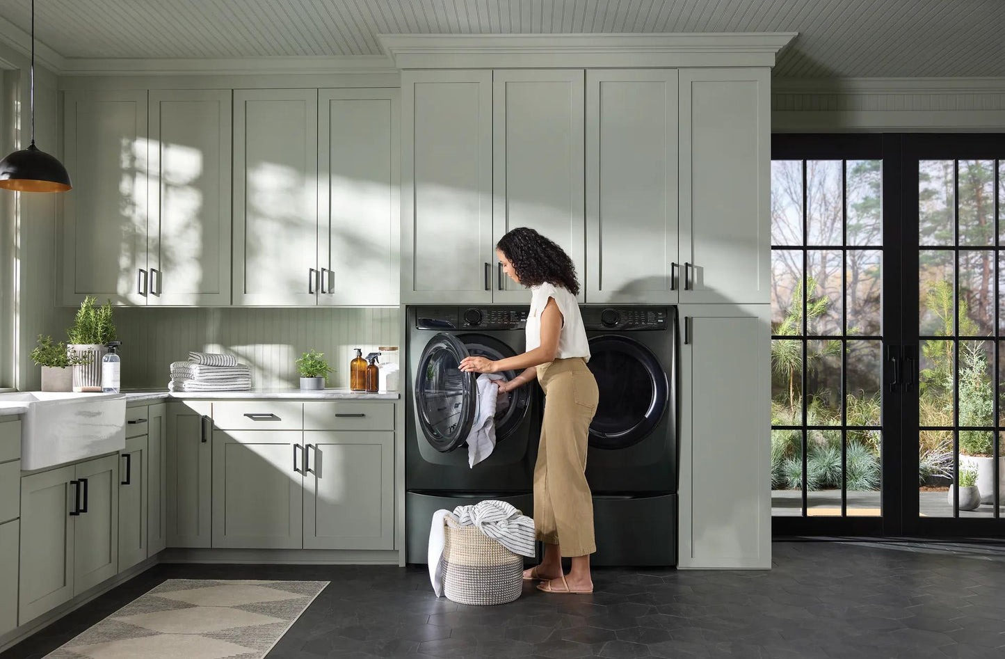 Woman loading dark gray front load gas dryer with digital controls in modern laundry room from Dryers collection