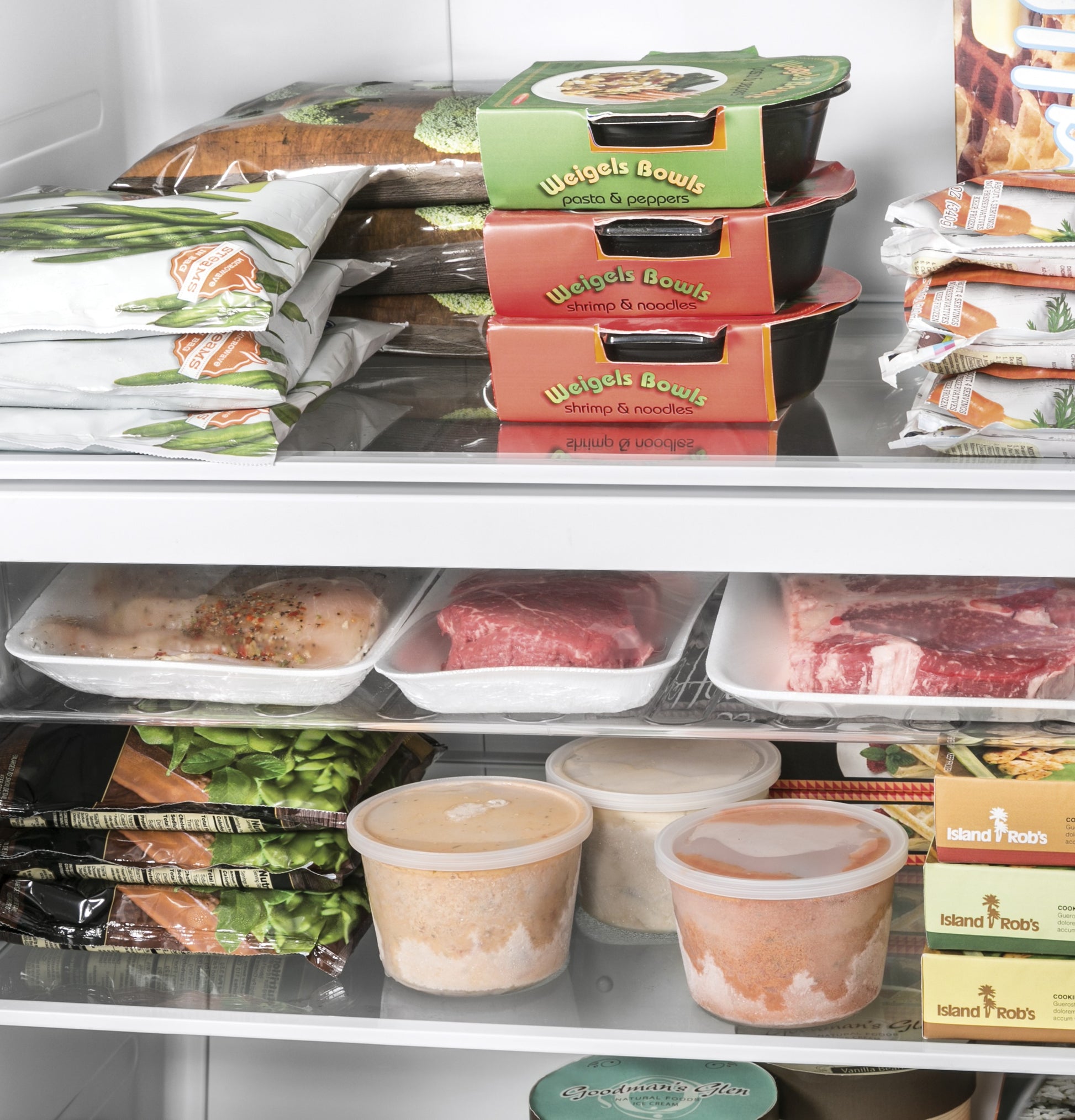 Interior view of an upright freezer stocked with frozen meals, raw meat, and packaged frozen vegetables in appliances collection