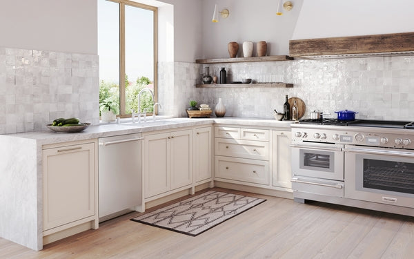 Spacious kitchen with white cabinetry, light wood floor, professional-grade stainless steel dishwasher and range from Appliances collection