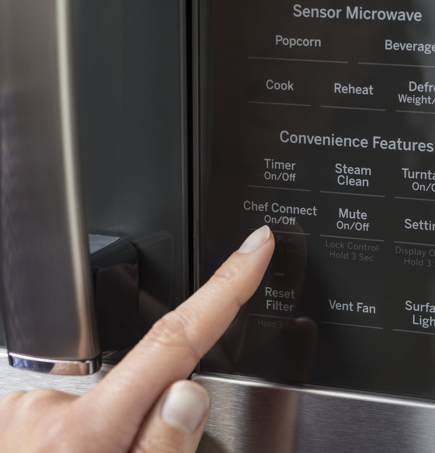 Close-up of finger pressing Chef Connect button on stainless steel sensor microwave control panel from kitchen appliances collection