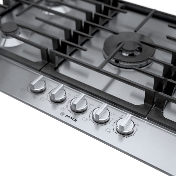 Stainless steel 36-inch gas cooktop with five control knobs and black cast iron grates from Bosch appliances collection