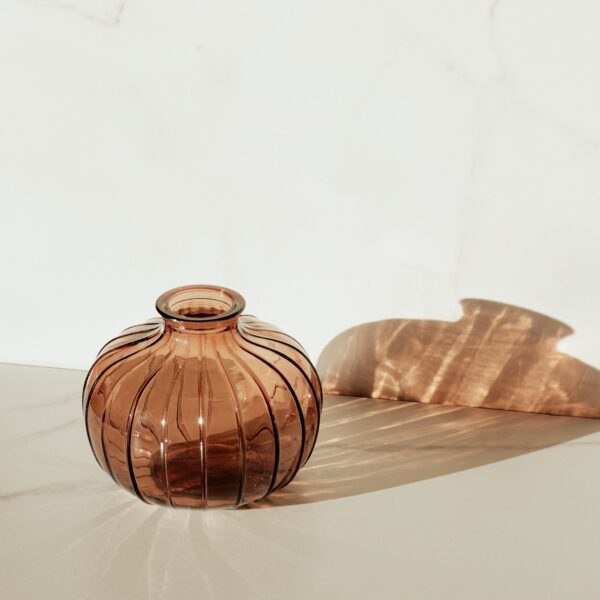 Compact amber glass vase with textured vertical lines, suitable for home accents and decor collections under $50