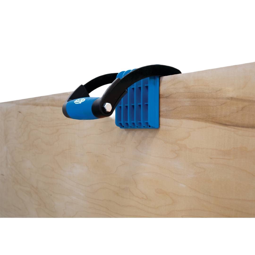 Blue and black ergonomic clamp handle securely gripping plywood for woodworking tool accessories and home improvement tasks