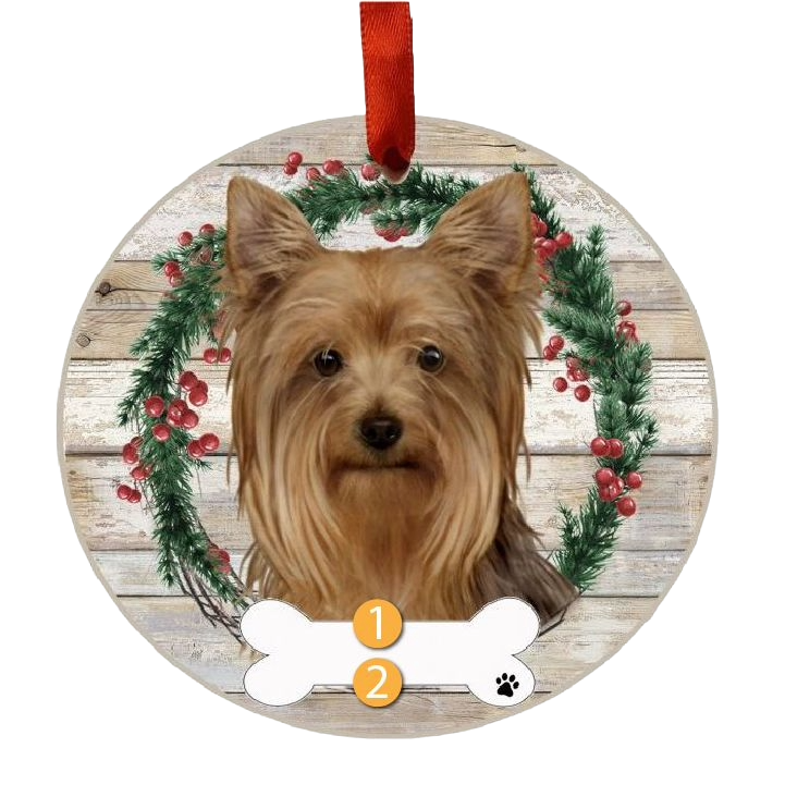 Round Christmas ornament featuring a Yorkie face with festive green wreath and red berries on rustic wood background