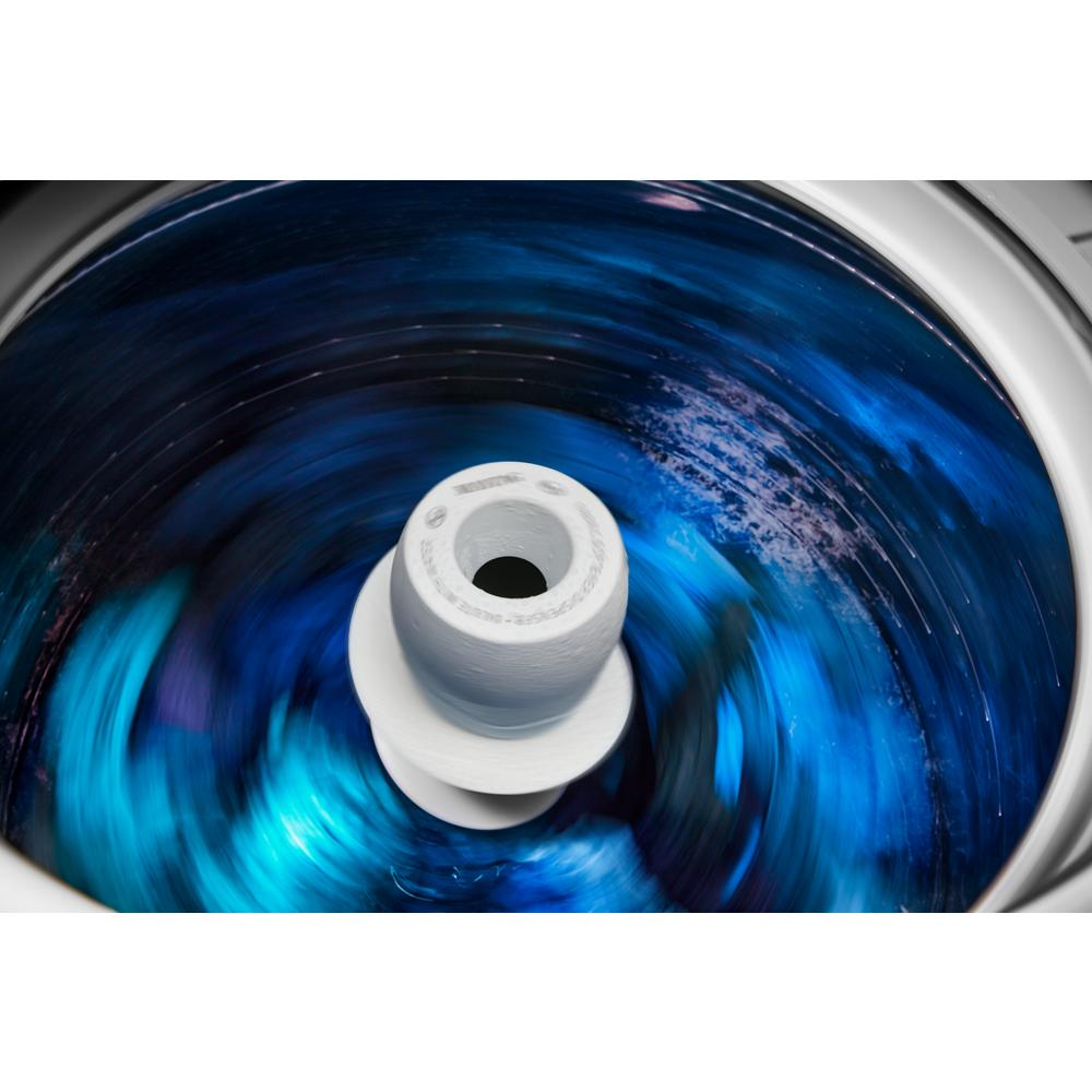 Interior view of top load washer agitator in motion with vibrant blue water during wash cycle, part of washers collection