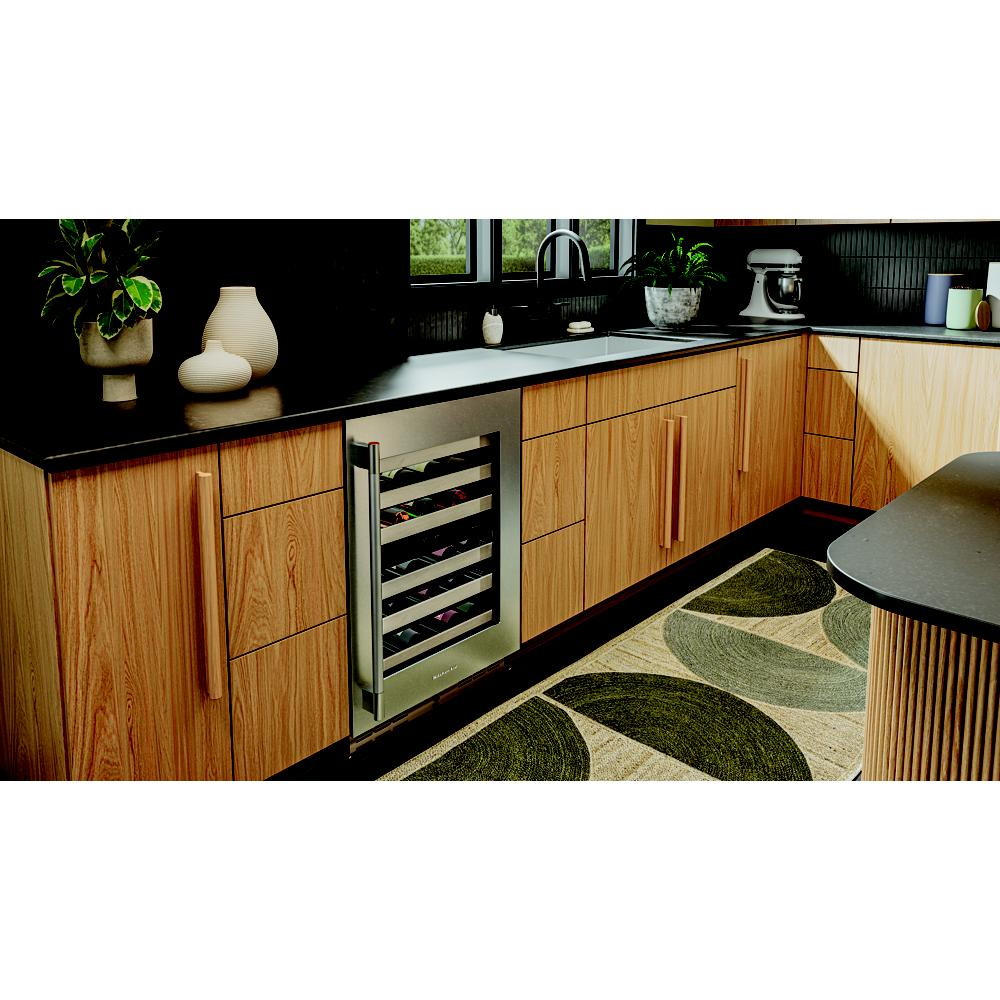 Stainless steel undercounter wine cooler with wood-front racks and glass door integrated into modern kitchen cabinetry