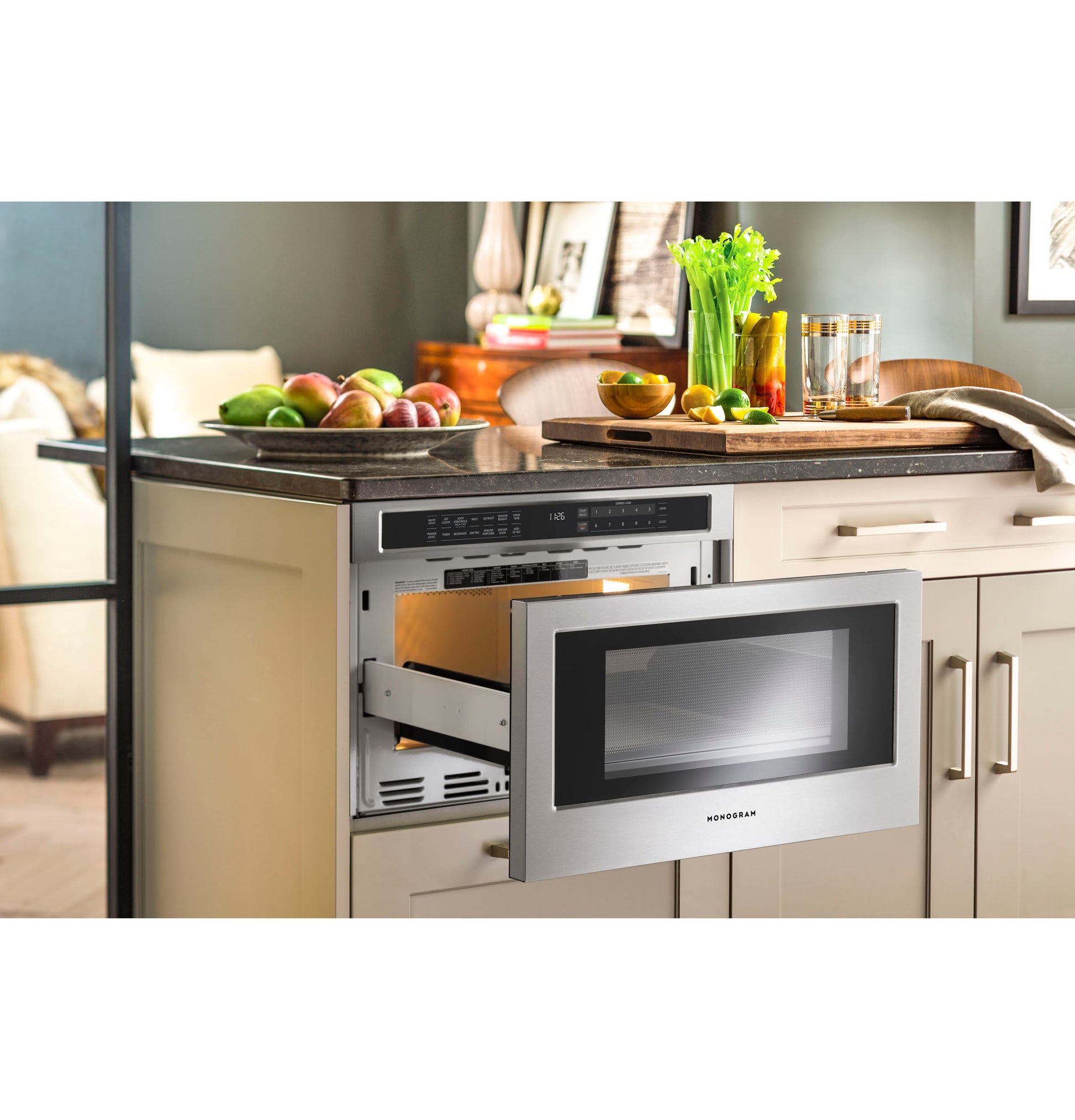 Open stainless steel built-in microwave drawer in kitchen cabinetry with fruit and vegetables on countertop