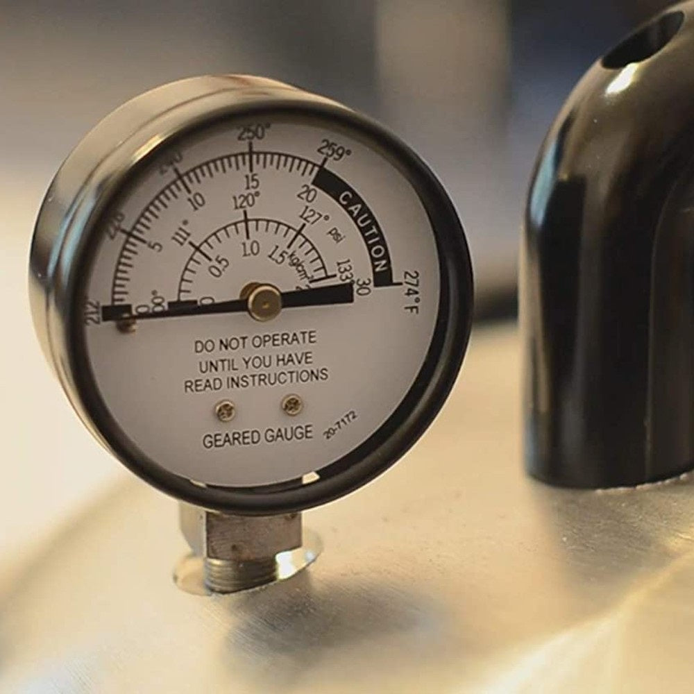 Close-up of pressure gauge with temperature markings on metal lid for kitchenware and cooking equipment collections