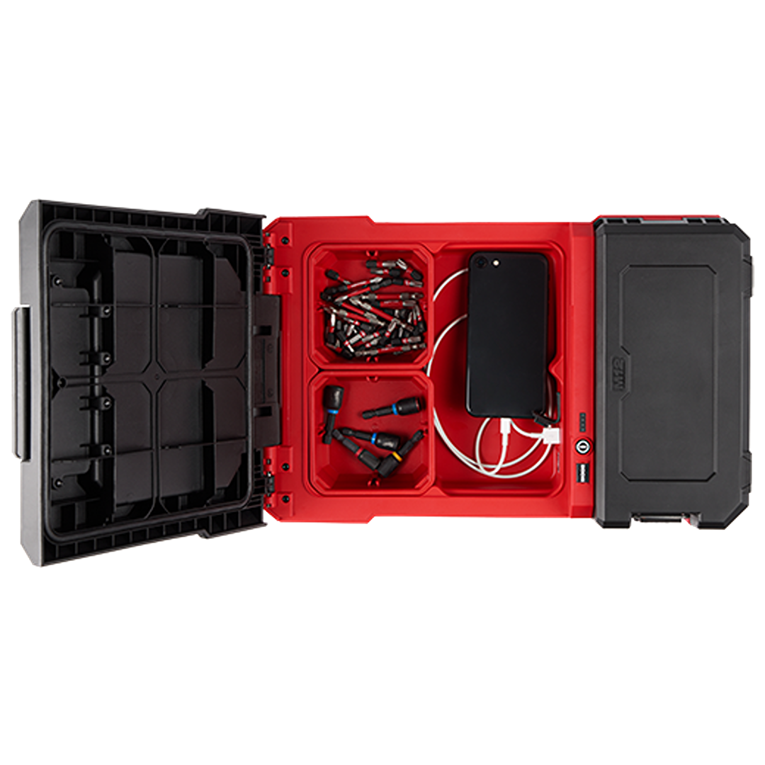 Open red and black Milwaukee PACKOUT storage box organizing assorted drill bits and a charging smartphone cable