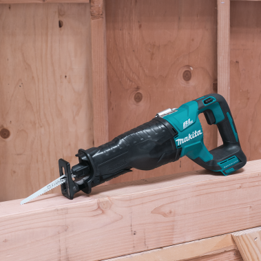 Makita cordless reciprocating saw resting on wood in a workshop setting for woodworking projects