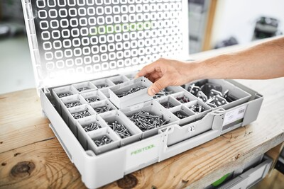 Gray plastic modular organizer with clear lid and adjustable compartments storing small hardware in workshop tool storage setup